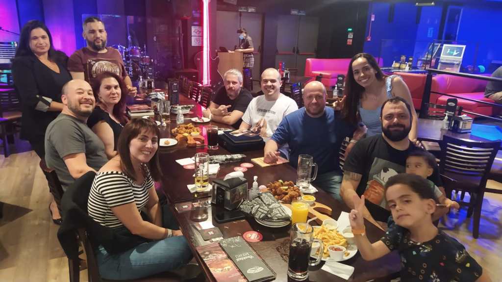 Amigos do Milo Ambrus comendo e bebendo em um barzinho.